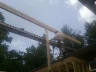 Carpenter setting a ridge beam over a new addition frame — Ice Dam Removal by Roofing Brothers in Prairie City